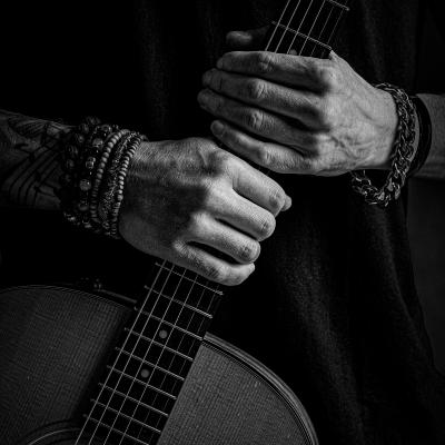 A close up picture of hands holding a guitar fret board
