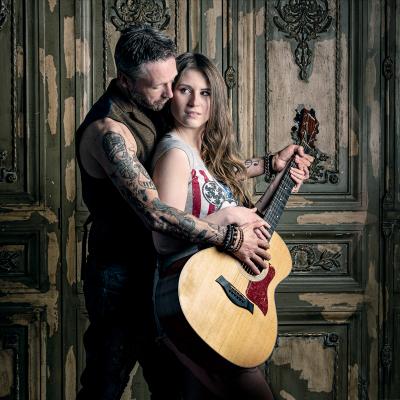 A picture of Ash Cooper with a woman and guitar